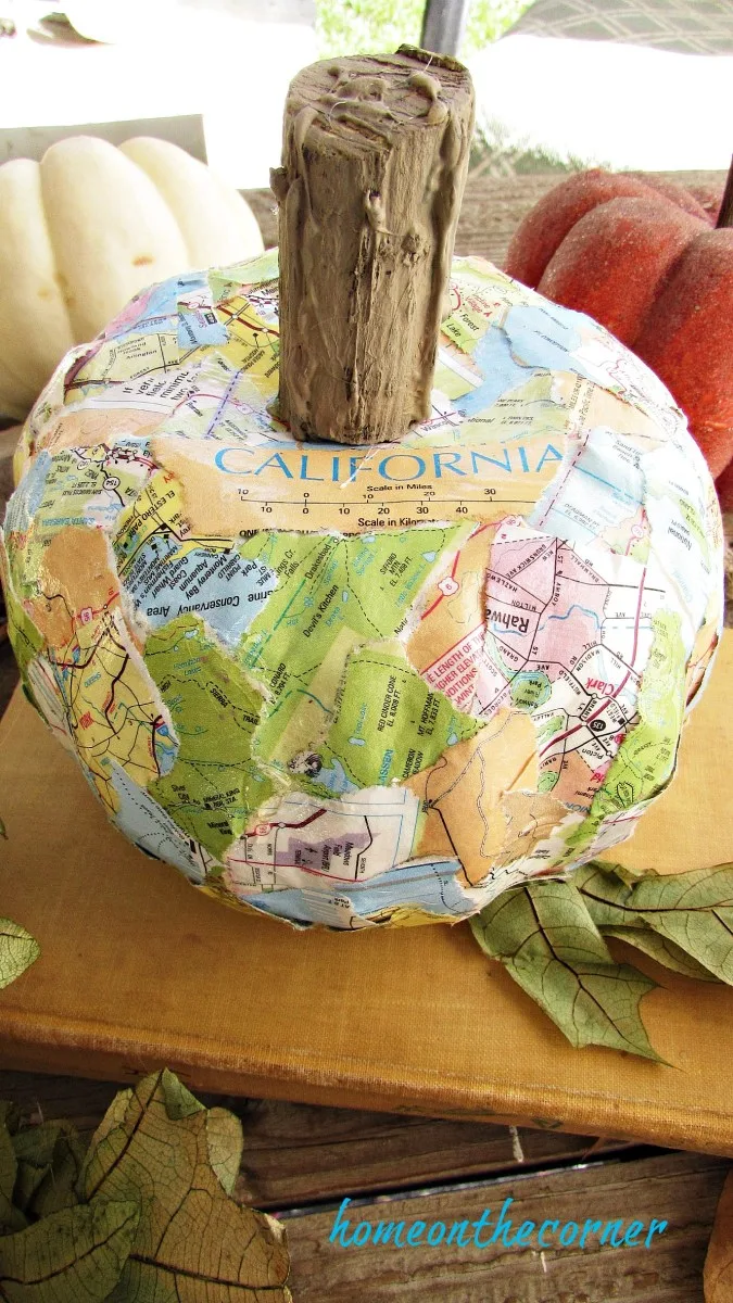Citrouille d’automne recouverte de morceaux de carte géographique