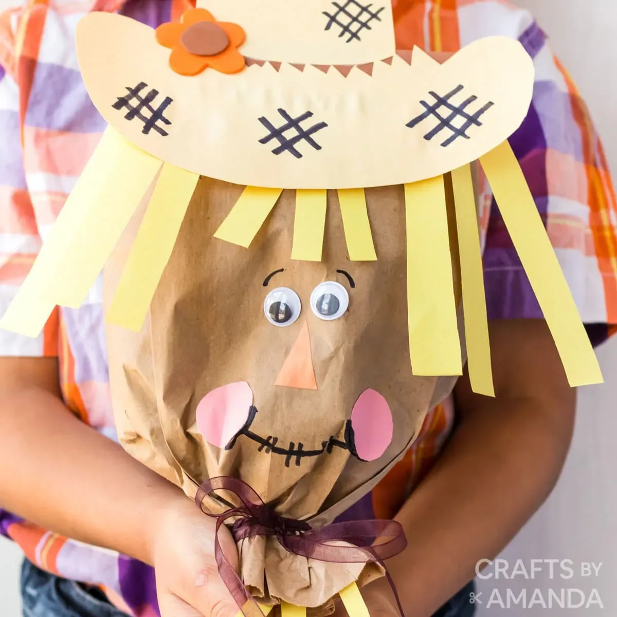 Épouvantail souriant réalisé avec un sac en papier