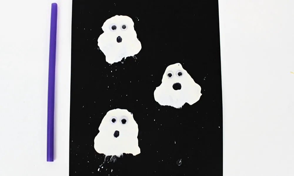 Fantômes blancs réalisés en peinture soufflée sur une feuille noire