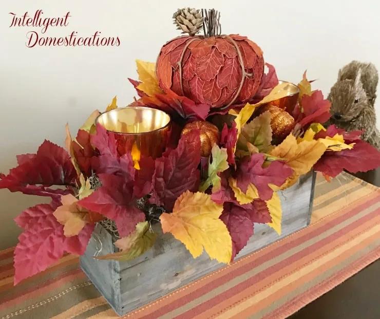 Jardinière rustique avec citrouilles et feuilles pour table automnale