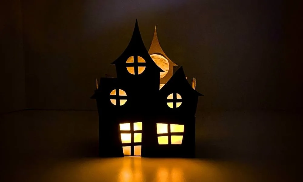 Maison hantée en papier noir éclairée de l’intérieur