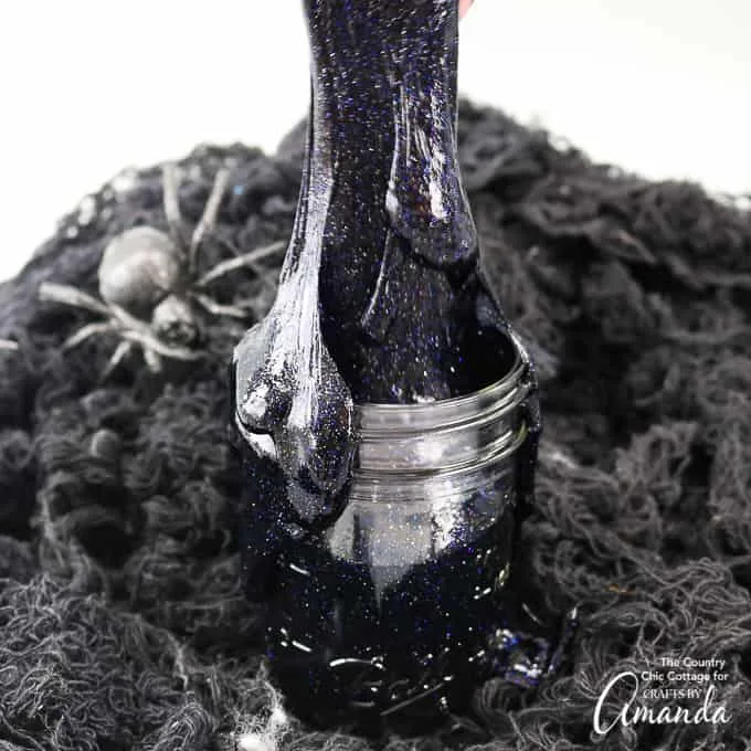 Slime noir et pailleté présenté dans un petit bocal