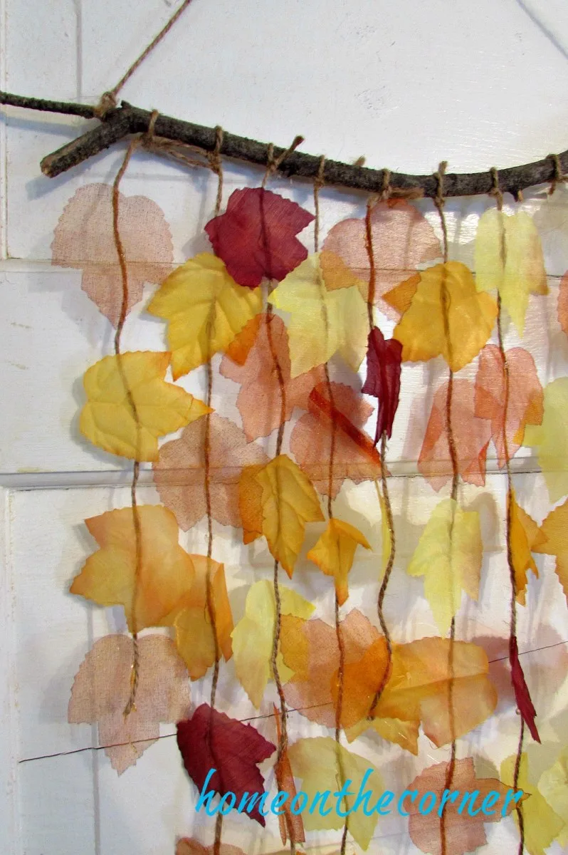Suspension murale d’automne avec feuilles colorées et branche naturelle