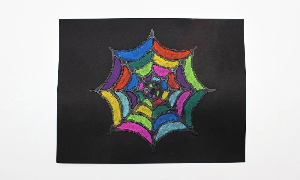 Toile d’araignée multicolore dessinée au pastel sur papier noir