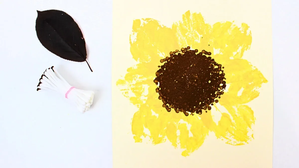Tournesol jaune peint avec des cotons-tiges et une feuille