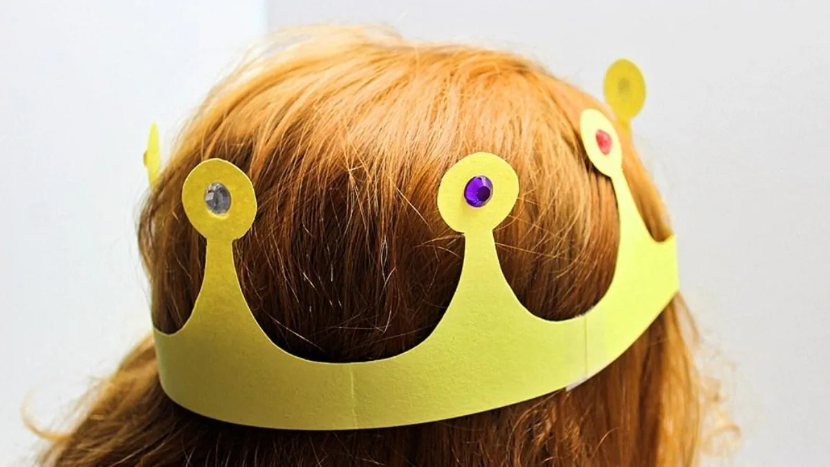 Couronne en papier jaune décorée portée pour un jeu de déguisement