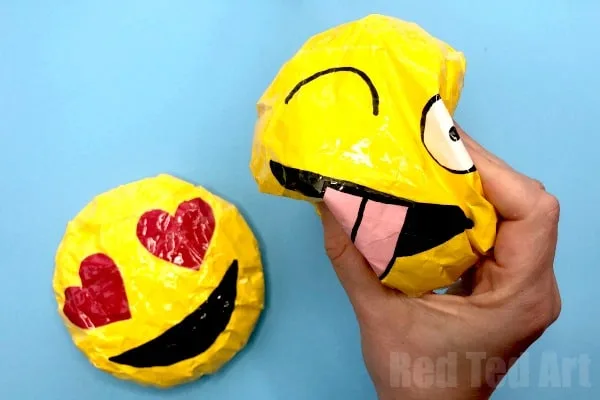 Deux squishies emoji en papier, dont un smiley aux yeux en cœur
