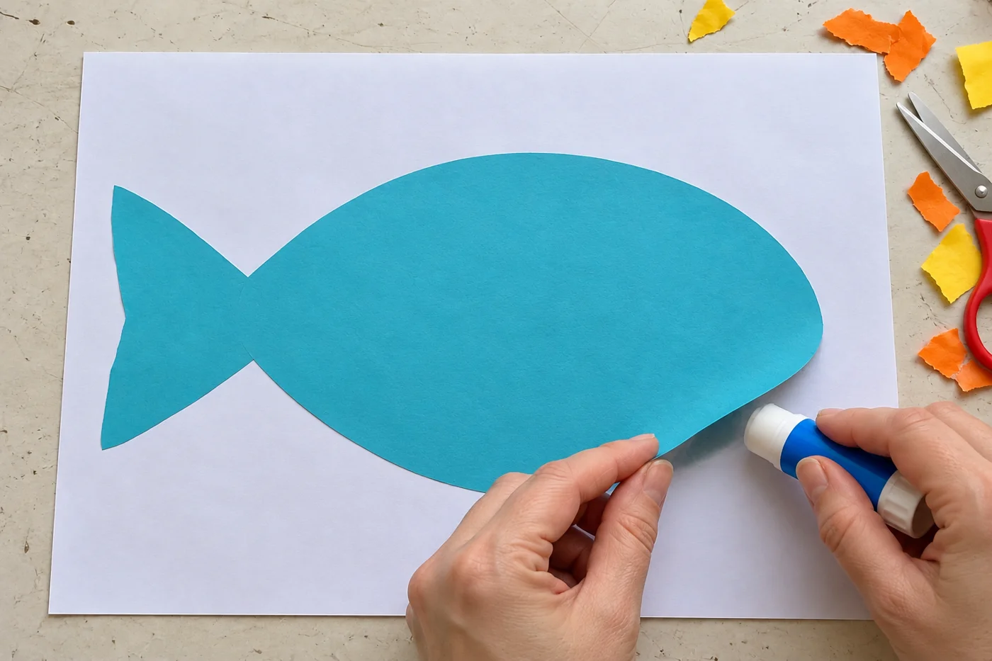 Silhouette bleue de poisson encore vierge, avec une queue triangulaire à gauche, collée sur une feuille blanche