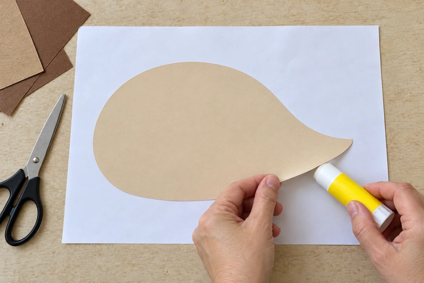 Silhouette beige de hérisson sans visage, au corps arrondi et au museau pointu, collée sur une feuille blanche