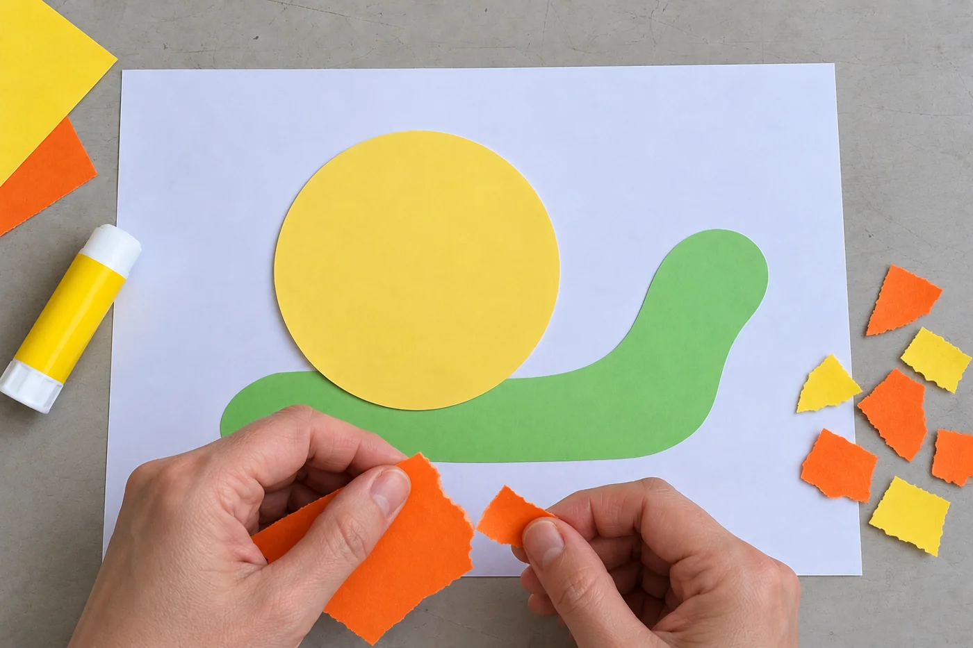 Mains déchirant du papier orange près du corps vert et du cercle jaune encore non décoré