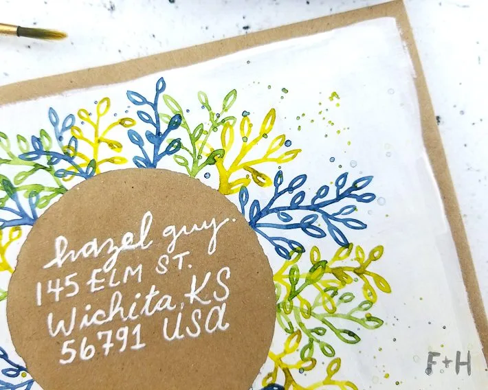 Enveloppe décorée à l’aquarelle avec une adresse manuscrite intégrée au dessin