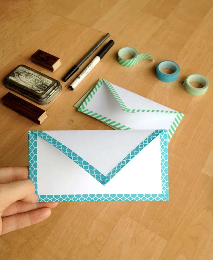 Enveloppe en papier blanc décorée avec du ruban adhésif coloré et des feutres