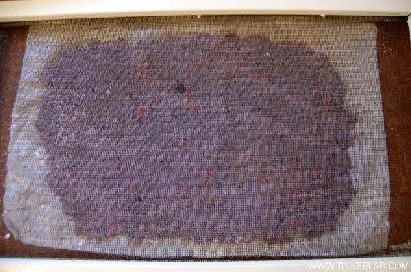 Feuilles de papier recyclé artisanal en cours de fabrication avec des fibres colorées