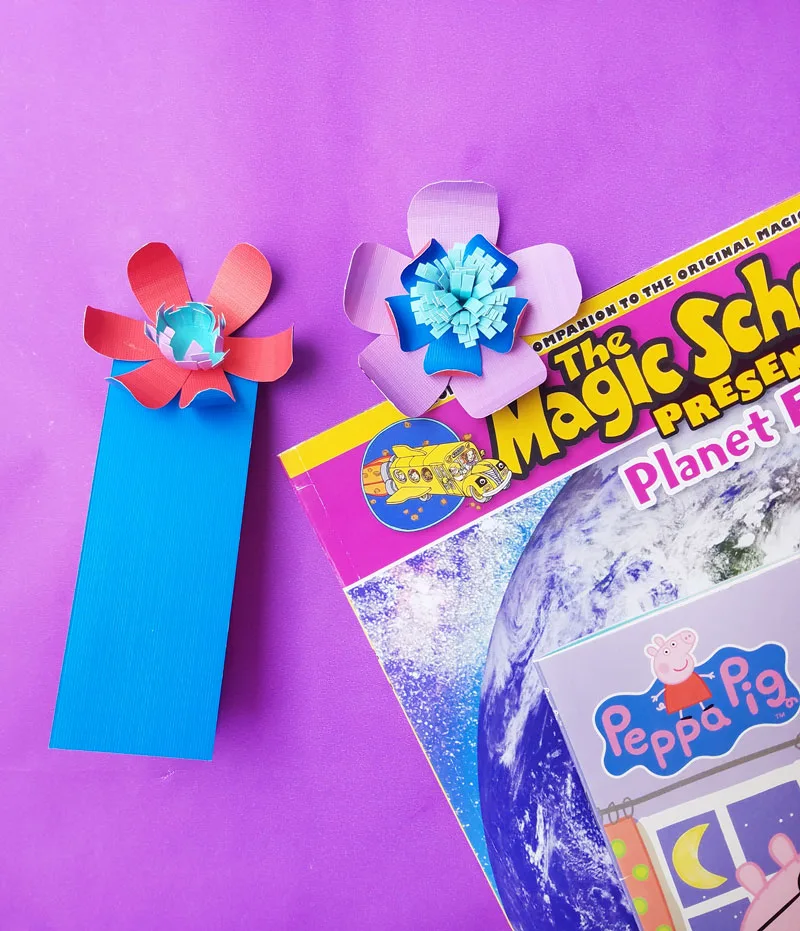 Marque-pages en papier décorés de fleurs colorées et glissés dans un livre