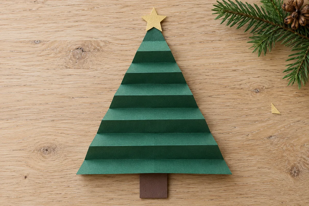 Sapin de Noël en papier vert plié en accordéon avec tronc brun et étoile dorée