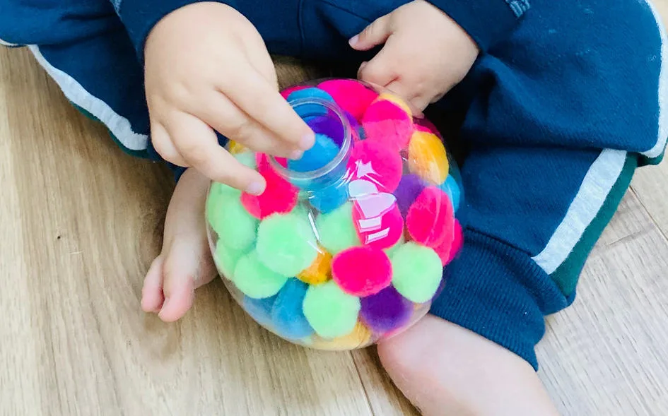 Une boule de Noël remplie de pompons – bricolage de Noël maternelle